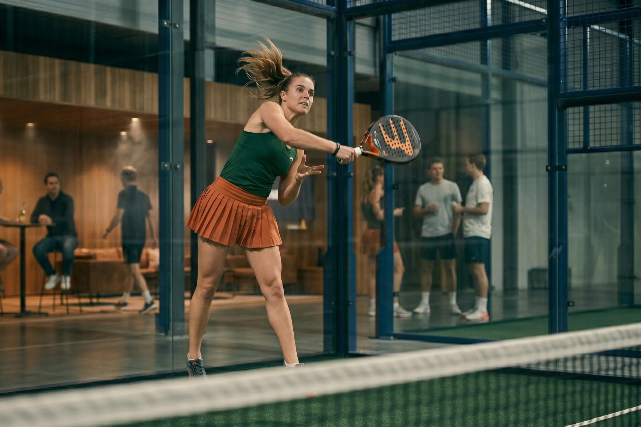 Padel player mid-swing on court